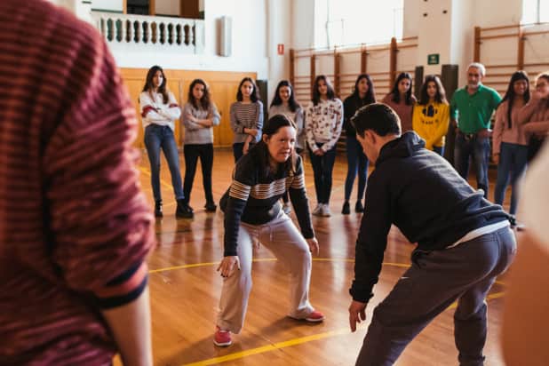 Corro de gente bailando en un gimnasio